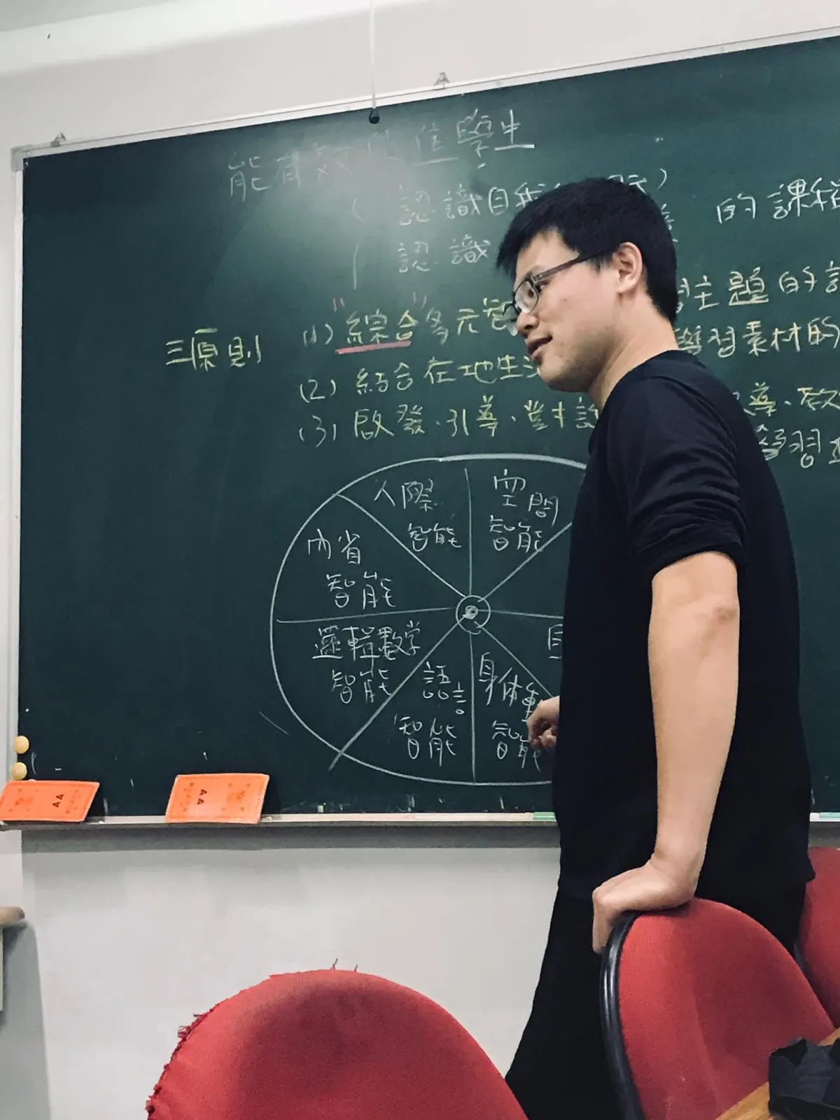 高心安站在黑板前，側身看向學生
